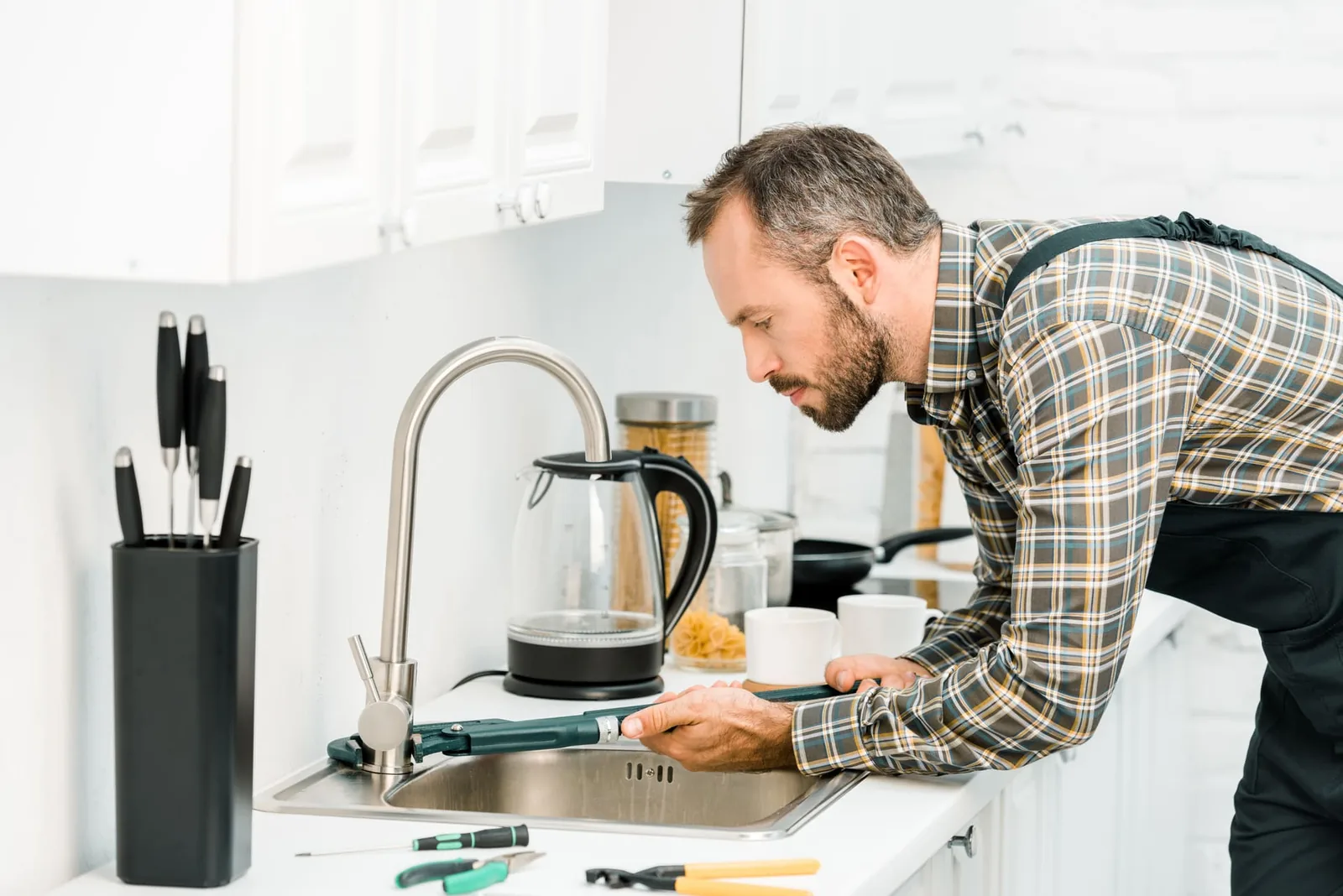 Handwerker prüft einen Küchenabfluss